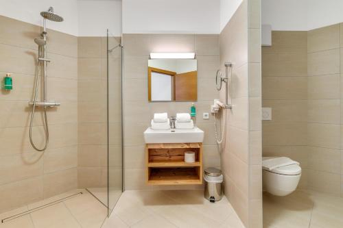 a bathroom with a shower and a sink and a toilet at STANTON Lodge in Sankt Anton am Arlberg