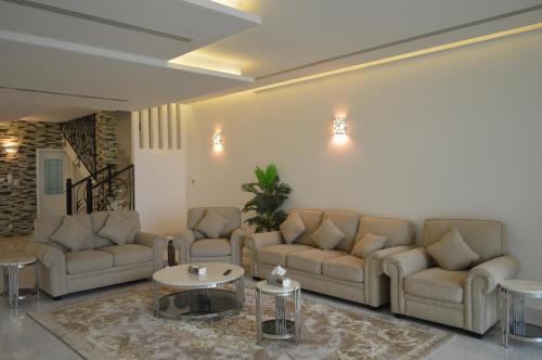 a living room with couches and a coffee table at شاليهات ويف -Wave Resort in Al Khobar