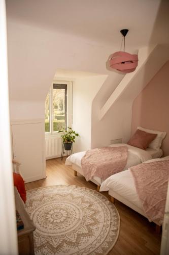 a bedroom with two beds and a pink ceiling at Maison de la Vicomté in Dinard