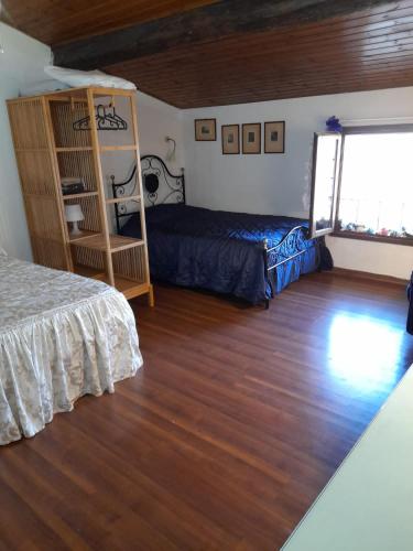 a bedroom with a bed and a shelf and a window at Appartamento “Il Borgo” in Peccioli