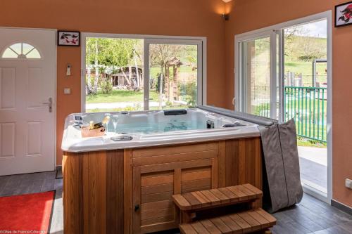 Aubigny-lès-SombernonにあるLes Gîtes du Griffon l'Erableの窓のある部屋にある大きな浴槽