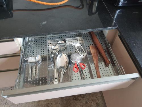 a metal strainer in a drawer under a table at Castle Bannerghatta Road in Bengaluru