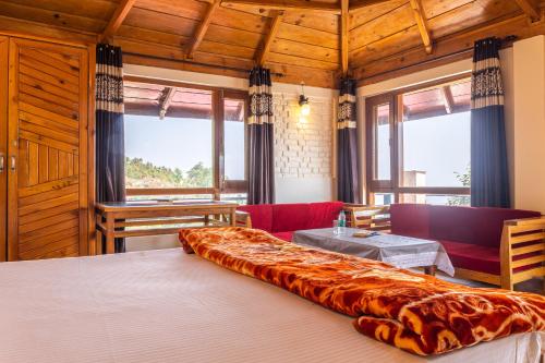 een groot bed in een kamer met een tafel en stoelen bij Himalayan Homz in Mukteswar