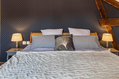 a bedroom with a large bed with two lamps at Les gîtes du Griffon le Pin in Aubigny-lès-Sombernon
