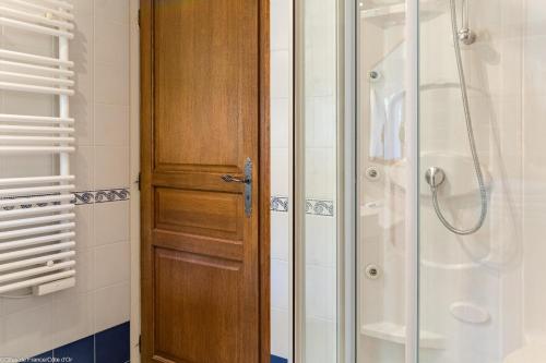 a bathroom with a shower and a wooden door at Les gîtes du Griffon le Pin in Aubigny-lès-Sombernon
