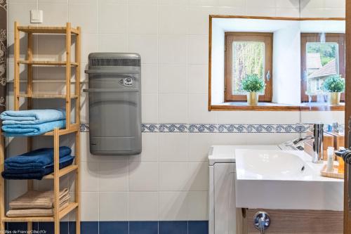 a bathroom with a trash can on the wall at Les gîtes du Griffon le Pin in Aubigny-lès-Sombernon