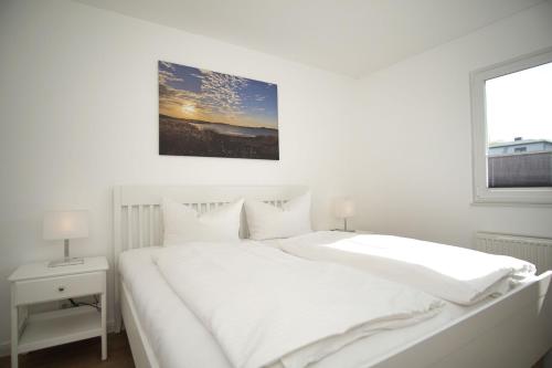 una camera bianca con un letto bianco e una finestra di Ferienwohnung mit Terrasse in ruhiger Lage - Haus Südperd FeWo Strandwinde a Thiessow