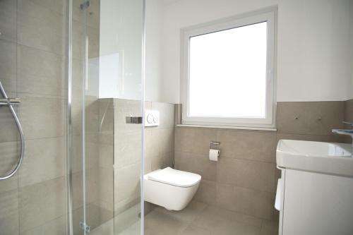 bagno con servizi igienici, lavandino e finestra di Ferienwohnung mit Terrasse in ruhiger Lage - Haus Südperd FeWo Strandwinde a Thiessow