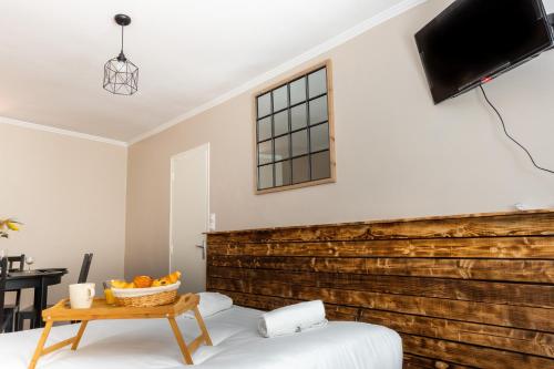 sypialnia z drewnianą ścianą i łóżkiem ze stołem w obiekcie Le Petit Mondi w mieście Mareuil-sur-Cher