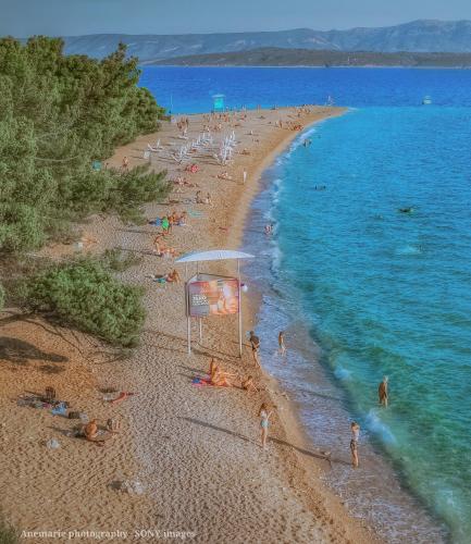 a group of people on a beach with the water at Kaya house in Nerežišća