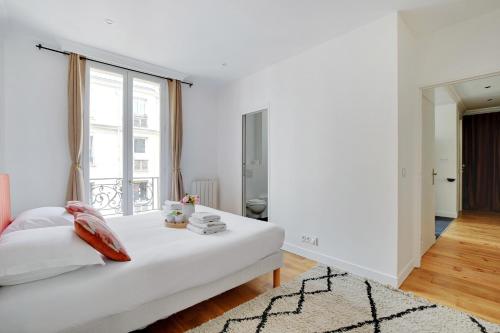une chambre blanche avec un lit et une fenêtre dans l'établissement Exclusive apartment - 1BR-4P - Arc de Triomphe, à Paris