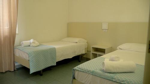 a room with two beds and a table with towels at Resort Sciabache in Zambrone