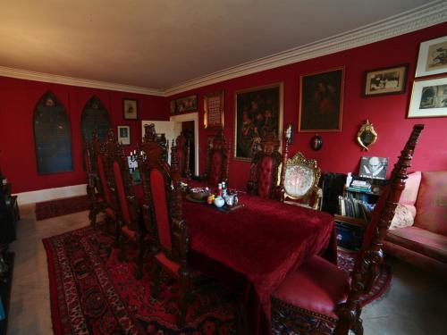 a red dining room with a table and chairs at The Covenstead in Glastonbury
