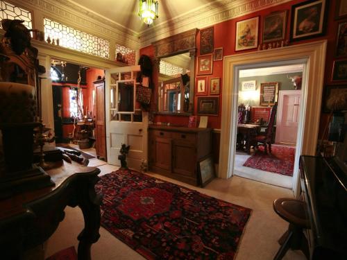 a living room with red walls and a red rug at The Covenstead in Glastonbury
