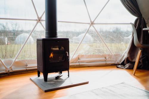 a wood stove in a room with a window at Beavers Retreat Glamping in Tenby