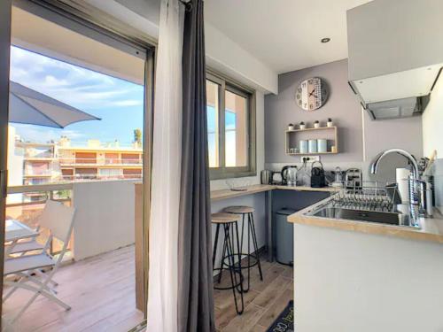 - une cuisine avec vue sur un balcon dans l'établissement Juan Les Pins Centre - Studio Neuf Avec Terrasse - 3 Mins Des Plages - Jazz Apartment, à Antibes