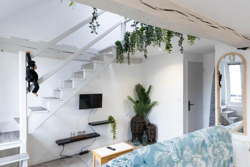 a living room with a blue couch and stairs at Doux Cocon Tropical au cœur du centre ville in Troyes