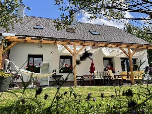 een huis met een pergola en een tafel en stoelen bij Vila Les Kralovstvi in Nemojov