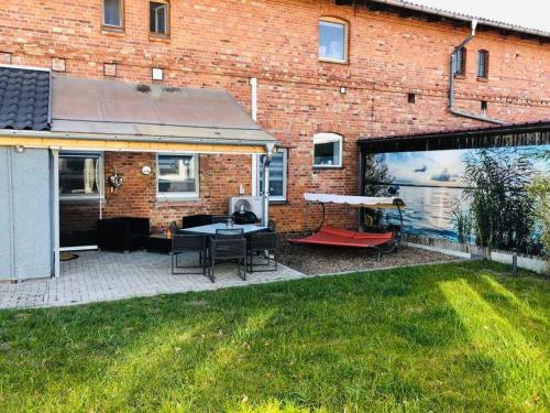 a backyard with a brick building with a patio at Ferienwohnung Seenrunde in Quadenschönfeld