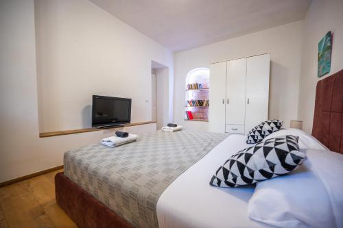 a bedroom with a large bed with a tv on the wall at Spacious and Bright 2BDR Apartment in the Old Town in Sarajevo