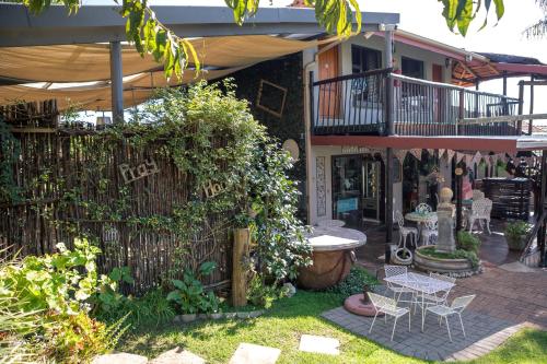 a garden with a fence and a table and chairs at Big 5 Guest House Witbank in Witbank
