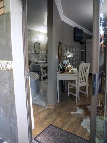 a living room with a table and a mirror at Big 5 Guest House Witbank in Witbank