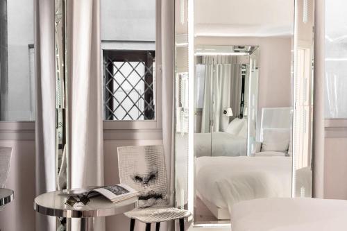 a white room with a bed and a mirror at Hotel Palazzina Grassi in Venice
