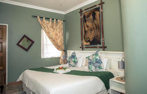a bedroom with two beds and a painting on the wall at Big 5 Guest House Witbank in Witbank