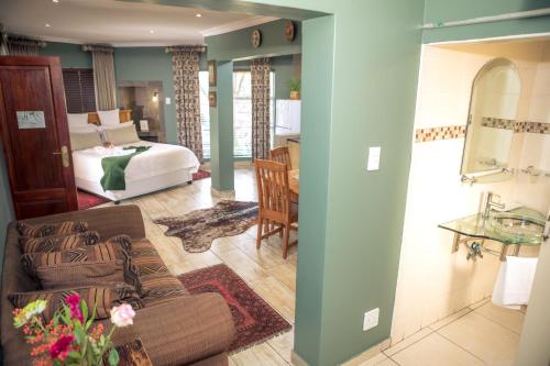a living room with a bed and a couch at Big 5 Guest House Witbank in eMalahleni