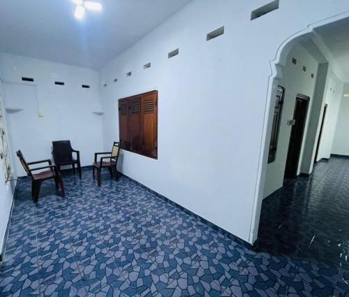 a hallway with two chairs and a wooden door at Jaffna RR Holiday Home Non AC in Jaffna