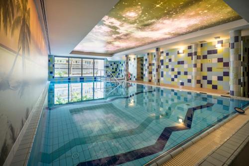 a large swimming pool in a building with a ceiling at Perła Bałtyku in Świnoujście