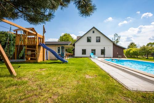 a backyard with a pool and a house at Vila Les Kralovstvi in Nemojov