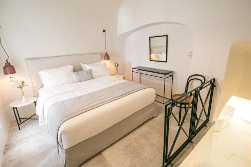 ein Schlafzimmer mit einem großen Bett und einem Tisch in der Unterkunft Elegant Santorini Villa Villa Spyros Villa Demi Private Hot Tub Air Conditioning 2 Bedroom in Oia