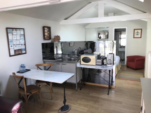 a kitchen with a table with a microwave on it at Clos Saint Nicolas in Neauphle-le-Château