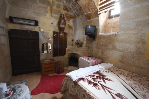 ウルギュップにあるDar Konak Pansiyonのベッドと暖炉付きの部屋