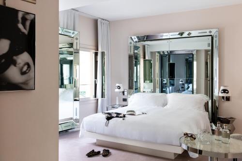 a bedroom with a white bed and a large mirror at Hotel Palazzina Grassi in Venice