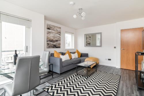 a living room with a couch and a table at Executive Apartment, Free Parking, West End in Aberdeen