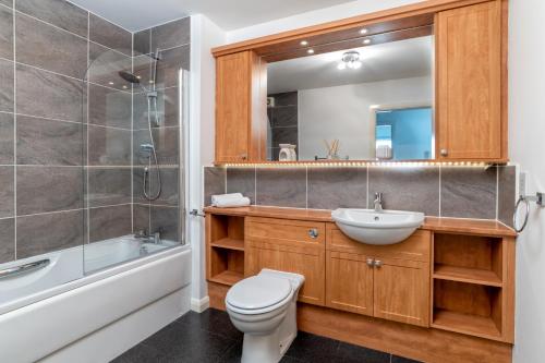 ein Bad mit einem WC, einem Waschbecken und einer Dusche in der Unterkunft Executive Apartment, Free Parking, West End in Aberdeen