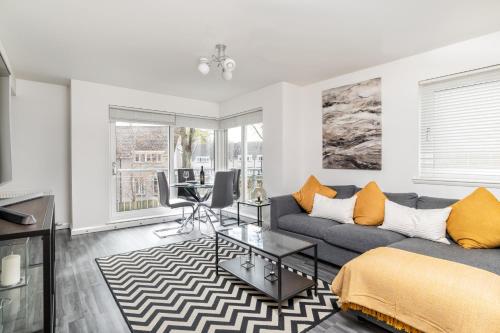 a living room with a couch and a table at Executive Apartment, Free Parking, West End in Aberdeen