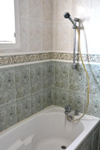 La salle de bains est pourvue d'une baignoire et d'une douche. dans l'établissement Villa F5-Wifi-piscine Saint Gely du Fesc, à Saint-Gély-du-Fesc