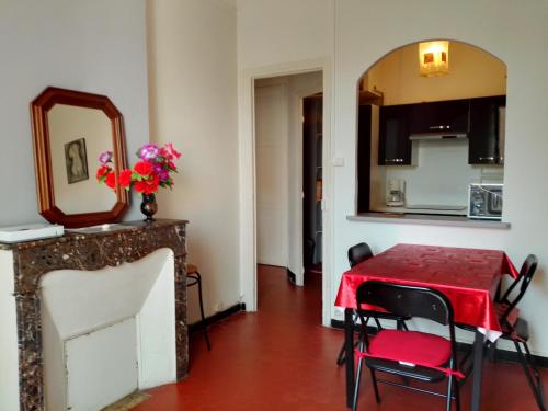 une salle à manger avec une table rouge et un miroir dans l'établissement Typical Toulon apartment 50M beaches, à Toulon