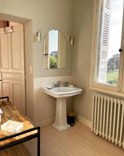 a bathroom with a sink and a mirror and a window at Le Château de Leugny in Oiron