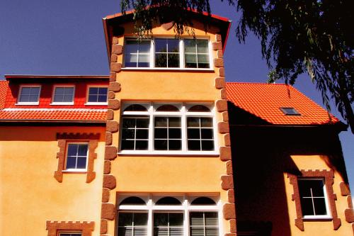 a tall building with an orange roof at Ostsee-Rittergut-Rügen mit BinzHotel & OrdensKapelle & RomantikGut in Binz