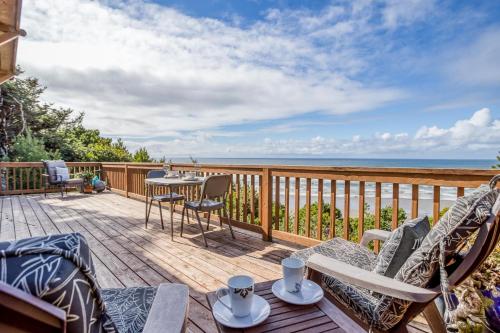 a deck with chairs and a table with a view of the ocean at Shorepine Retreat in Newport