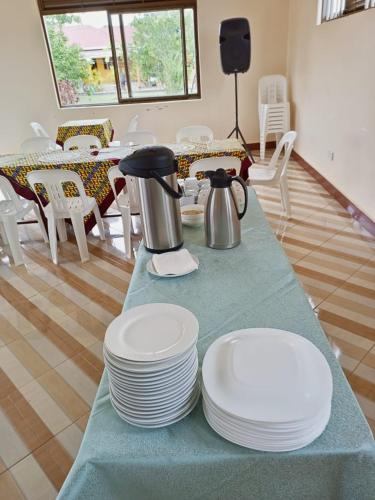 ein Tisch mit Tellern und einer Teekanne darauf in der Unterkunft Gugga Resort in Soroti