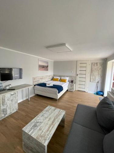 a bedroom with a bed and a couch and a table at Willa Atlantis in Mielno