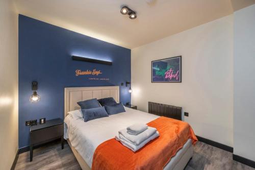 1 dormitorio con 1 cama grande y paredes azules en The Peaches & Cream - Soho - by Frankie Says, en Londres