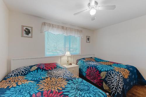 a bedroom with two beds and a ceiling fan at Raffles in Ocean City