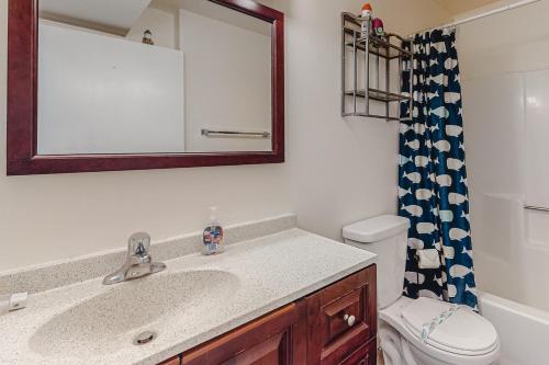 a bathroom with a sink and a mirror and a toilet at Raffles in Ocean City