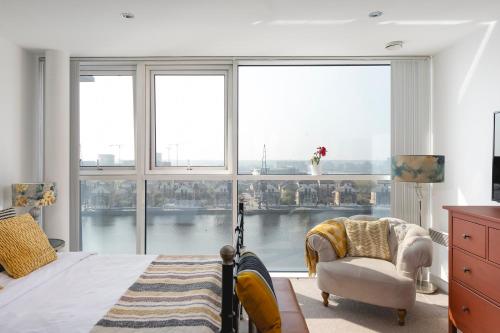 ein Schlafzimmer mit einem Bett und einem großen Fenster in der Unterkunft Serene Waterfront Rooms - ExCel in London